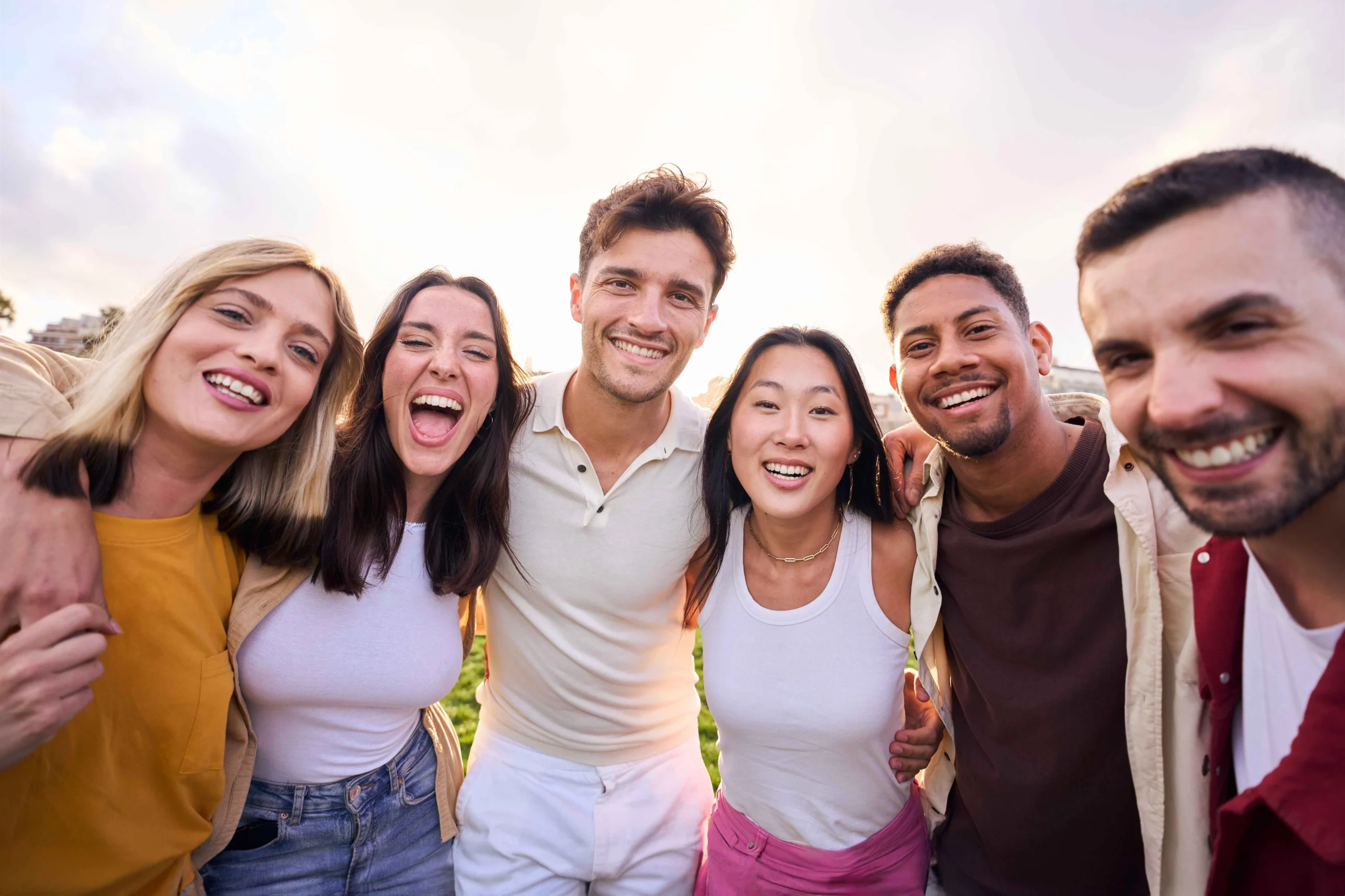 Group of friends interacting, with the central figure showing a bright, confident smile